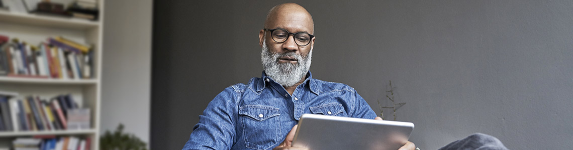 Man using tablet to look over Beaumont pricing and financial transparency information