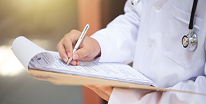 Doctor holding clipboard and taking notes