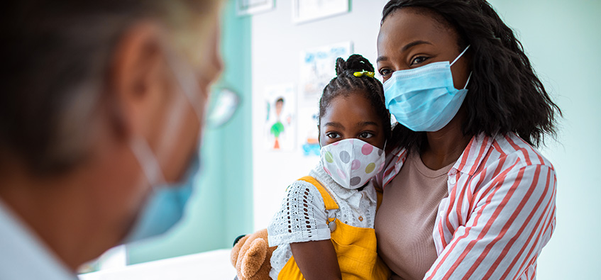 Mother and daughter at pediatric urology office wearing masks