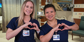 Two female nurses make hands into heart shape