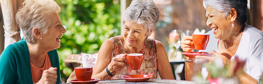 Group of happy senior females drinking coffee