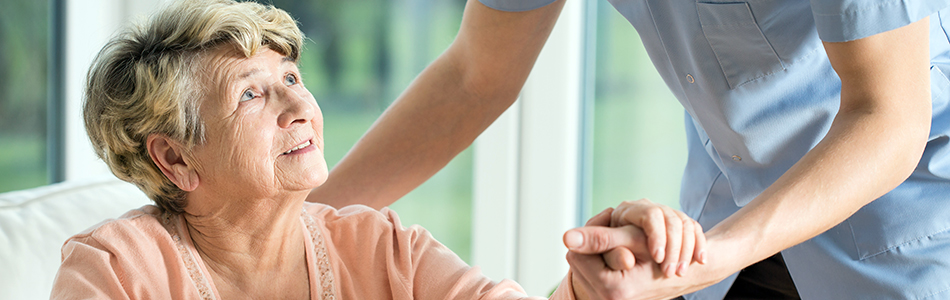 Senior woman with Alzheimer's disease receives help from nurse