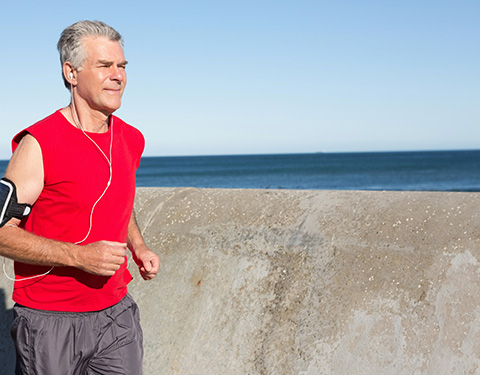 Senior male suffering from hip pain goes for a run