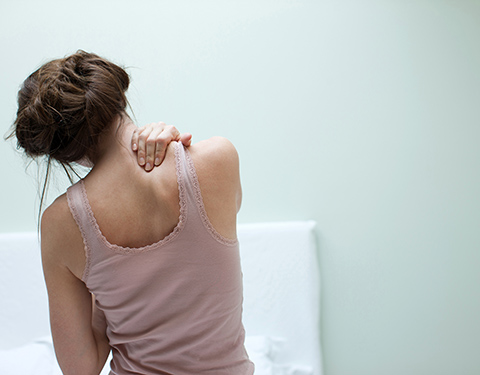 Woman rubbing aching back and spine